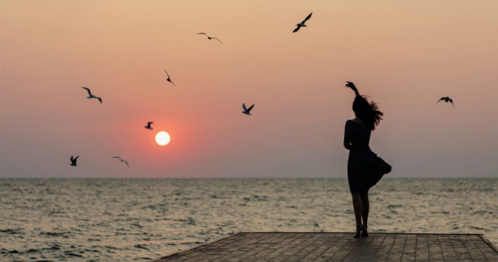 A sunrise over calm water with birds in flight, symbolizing new beginnings, creativity, and the inspirations shared at Good Life Chat
